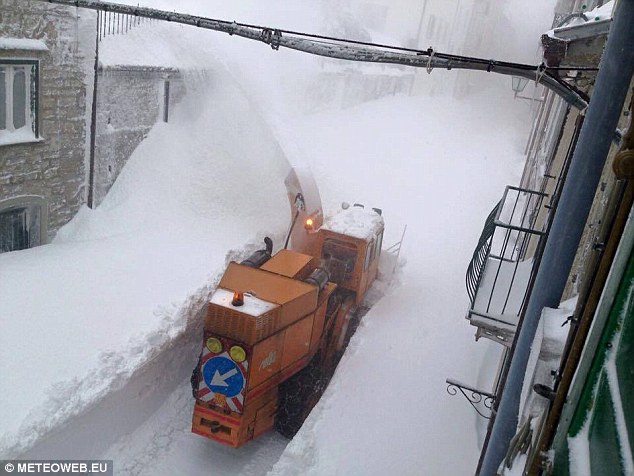 Even heavy machinery had difficulty making its way through the city streets. Pictured is a snowplow attempting to carve a path