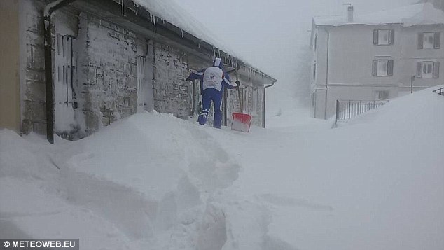 A resident of Capracotta attempts to dig his way through the record-breaking snowfall