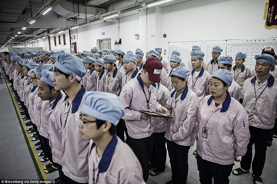 Clocking in: A supervisor holds an iPad as he checks an employee's badge during roll call at a Pegatron factory in Shanghai, China Read